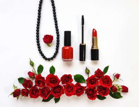 Decorative flat lay composition with woman cosmetics and red rose flowers. Flat lay, top view on...