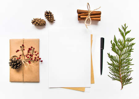 Vintage gift box in eco paper and a letter on white background. Present decorated with natural elements. Christmas or other holiday concept, top view, flat layの写真素材