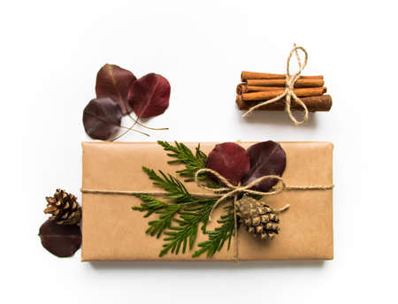 Vintage gift box in eco paper on white background. Present decorated with natural parts. Christmas or other holiday concept, top view, flat layの写真素材