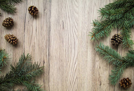 Christmas wooden background with natural decoration: fir tree and cones. Rustic wooden background, view from above. Flat lay, top viewの写真素材