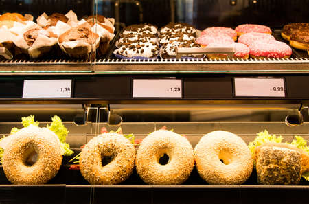 Bright shot of burgers, donuts and sandwiches in a bakery or shop glass counter. Shiny showcase of...
