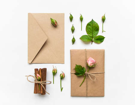 Vintage gift box and envelope in eco paper on white background. Presents decorated with cinnamon and roses. Valentine's day or other holiday concept, top view, flat lay, overhead viewの写真素材