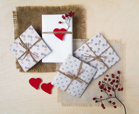 Shot of handmade gift boxes over wooden background. Rustic style, cute paper DIY decoration on...