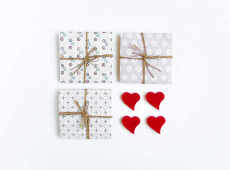 Shot of handmade gift boxes decorated with hearts on white background. Rustic style, cute paper DIY decoration. Valentine's day or other holiday concept. Flat lay, top viewの写真素材