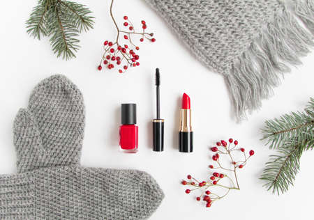 Winter accessories collage with cosmetics, woolen scarf and mittens decorated with berries and fir tree on white background. Flat lay, top viewの写真素材