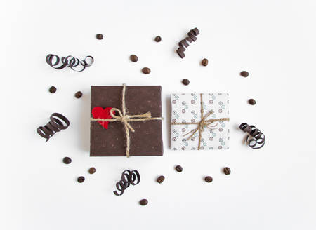 Handmade gifts on white background decorated with hearts, coffee and paper serpentine. Rustic style,...