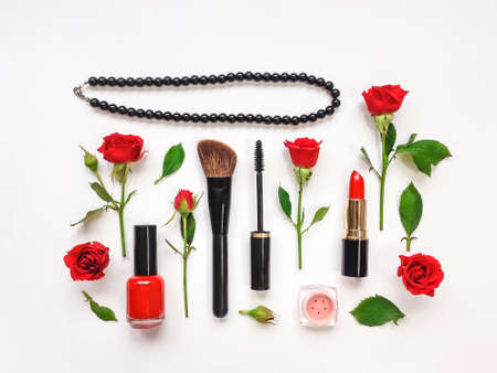 Decorative flat lay composition with woman cosmetics and red rose flowers. Flat lay, top view on white background, make up compositionの写真素材