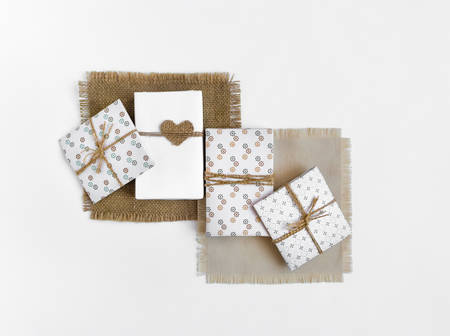 Handmade gift boxes on white background. Rustic style, cute paper DIY decoration on sackcloth napkins. Valentine's day or other holiday concept. Flat lay, top viewの写真素材