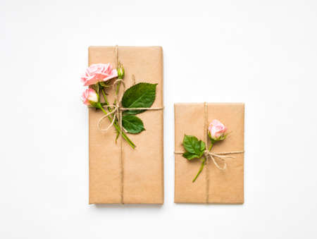 Vintage gift boxes in eco paper on white background. Presents decorated with rose flowers and...