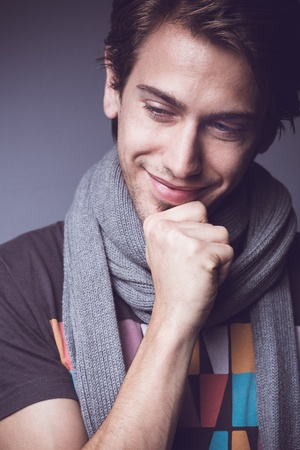 Happy young man  Looking down and smiling, while holding his chin の写真素材