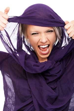 Beautiful woman in a purple headscarf lifting it clear of her face with her hands and yellingの写真素材