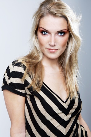 Studio shot of a young and attractive female model showing confidence wearing a black and white stripes top, isolated on white background.の写真素材