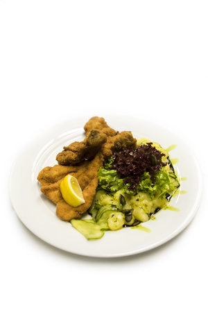 High angle view of a serving of fried fish and salad garnished with lemon for dinnerの写真素材