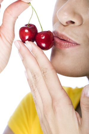 Close-up of a woman holding and kissing a couple of red ripe cherriesの写真素材