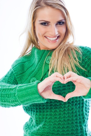 Blond girl forming a heart with her handsの写真素材