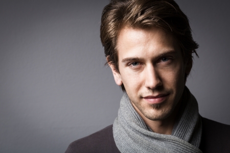 Dark moody studio Portrait of an attractive man looking out of the shadows with an enigmatic expressionの写真素材
