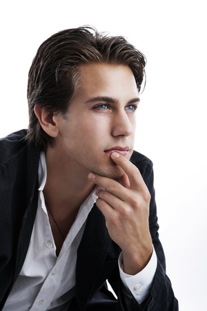 Pensive young man, chin in hand , on whiteの写真素材