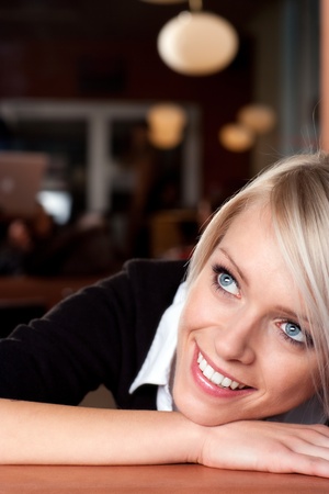 Cheerful girl resting on arms and looking upの写真素材