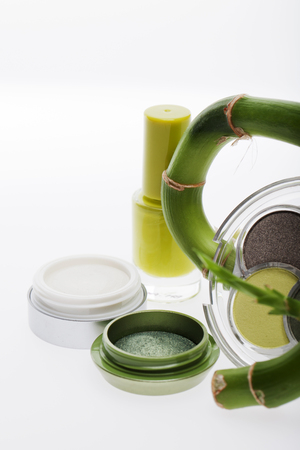 Natural cosmetics and makeup made from plant extracts and herbs with cream and eye shadow in shades of green with fresh bambooの写真素材