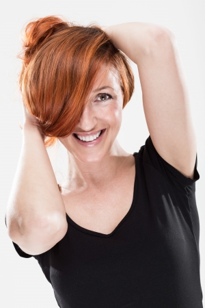 Very happy and smiling redhead woman with sexy expression while playing with her hairの写真素材