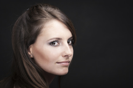 Timeless beauty portrait of a beautiful woman in a black backgroundの写真素材