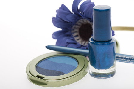 Modern fashion and beauty cosmetics in a colorful blue with eye makeup and nail varnish decorated by a blue Gerbera daisy on a white backgroundの写真素材