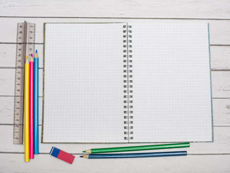 An open notebook and pencils on the table.
