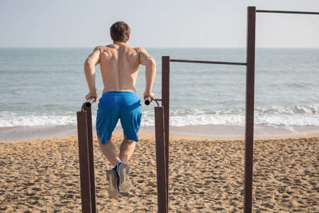 Male doing pull ups on bars. Sport and healthy lifestyle concept.