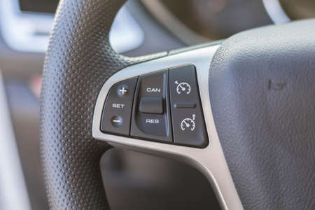 Black steering wheel with multifunction buttons for quick control. Cruise control buttons. Close-up...