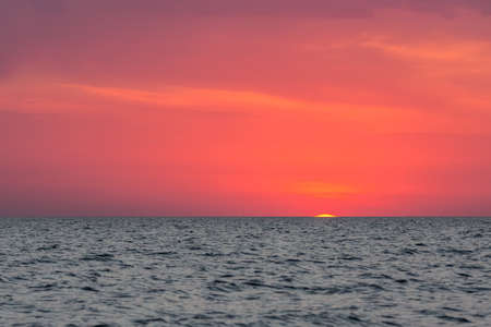 The sun peeked over the horizon at dawn. Dawn over the sea.の写真素材