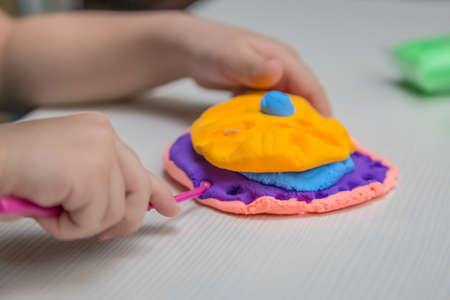 Child playing with colorful clay making figures - closeup on hands.の写真素材