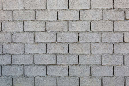 A rough gray wall of concrete blocks.の写真素材