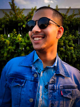 A young adult Indian man wearing sunglasses & smiling. This image was taken on DEC. 2019.の写真素材