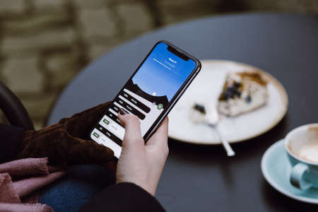 A image of woman's hands holding mobile phone with while having lunch in modern loft cafe at New Delhi. This image was taken on June 2019.の写真素材
