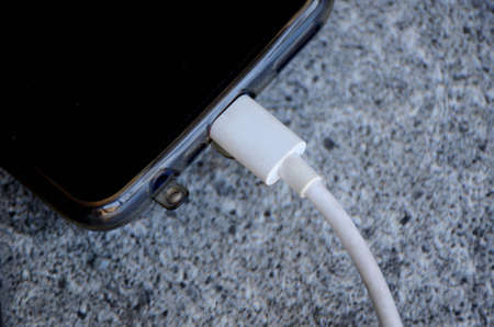the mobile charger data cable with phone on the grey background.