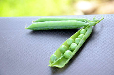the green ripe peas with beans on the brown background.