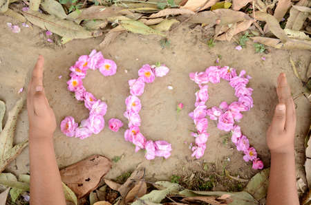 pink flower writing with hands social cooperative responsibility on the clay brown drilled leafs...