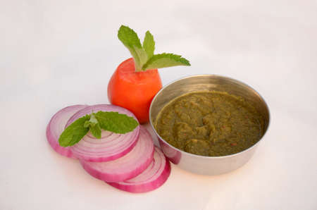 sliced onion with tomato, mint sauce and green mint isolated on the white background.