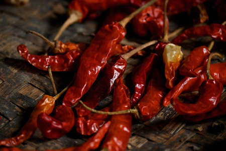 closeup the bunch red ripe dried chilly in the wooden basket over out of focus brown background.の写真素材