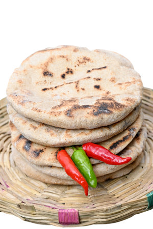 closeup the bunch brown color tortilla with red green chilly in the grey brown bucket on the white background.の写真素材