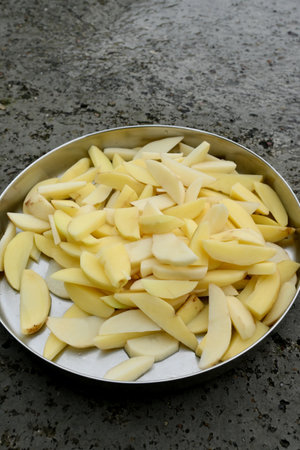 closeup the bunch ripe white sliced potato in the metal plate soft focus natural grey brown background.の写真素材