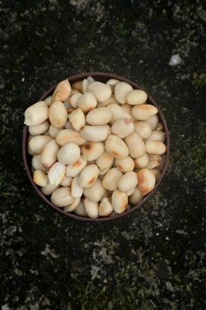 closeup the bunch peels and dry peanut in the plastic maroon bowl soft focus natural white brown...
