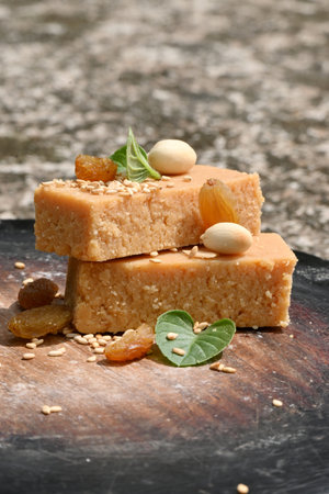 closeup the bunch brown color condensed milk sweet with green mint and pea nut,sesame grain,drilled grapes on the brown wooden soft focus grey brown background.の写真素材