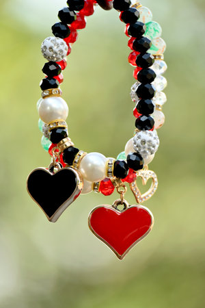 closeup the pair of white,red,black color plastic beads with heart shape bracelet soft focus natural...