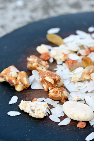 closeup the mix snack food drilled rice coconut,raisins,peanut ,sesame seeds in the wooden on the grey brown background.の写真素材