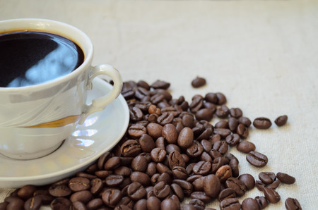 Half of the coffee cup and saucer on a linen tablecloth.