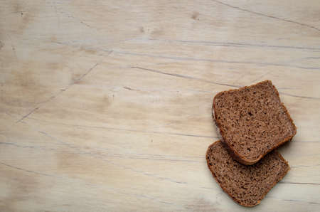 Two slices of bread on a wooden table. The view from the top. Light background.の写真素材