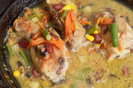 roasted chicken legs with vegetables in a panの写真素材