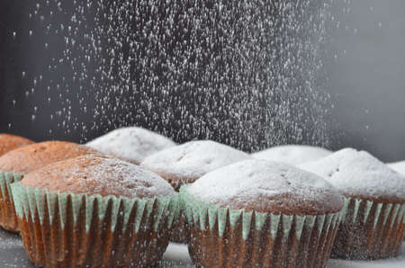 Falling sweet sugar on chocolate muffinsの写真素材