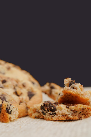 Golden brown, chocolate chip cookies over wooden table. Shallow depth of field.の写真素材
